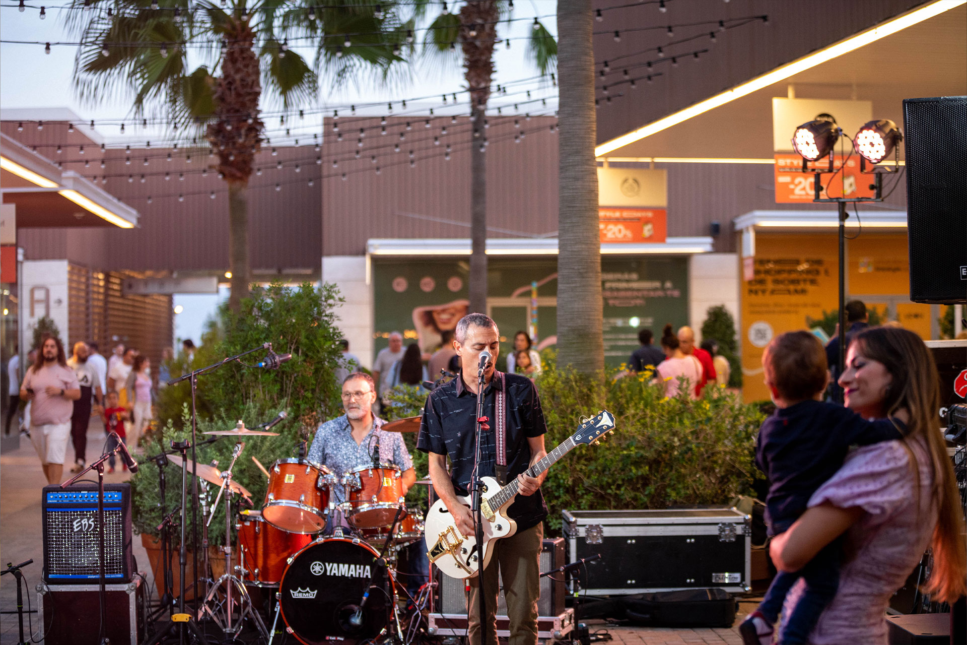 concierto en the style outlets en el que se ve cantante con guitarra y un bateria tocando