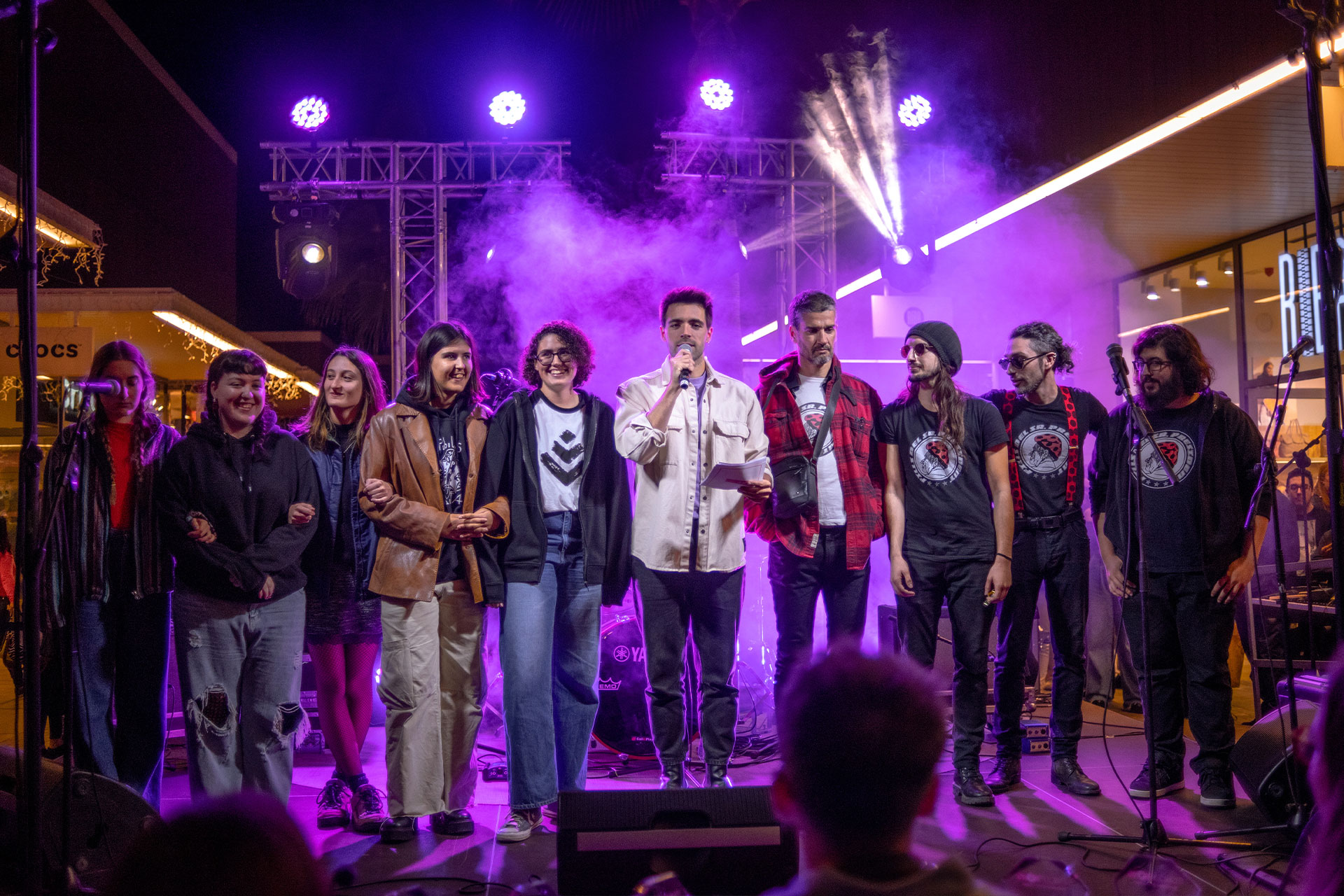 grupo de personas celebrando concurso de musica en el escenario