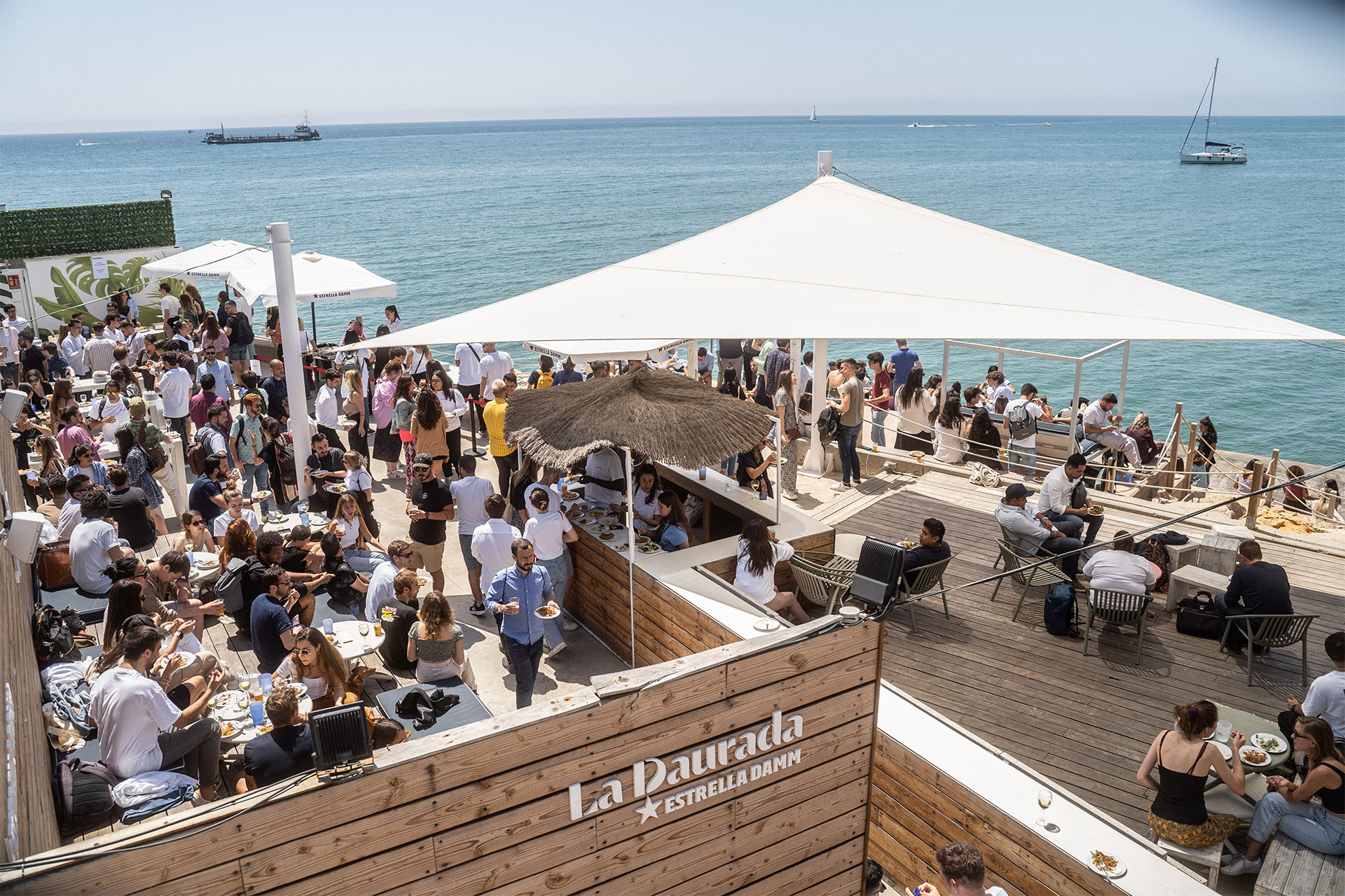 celebracion al aire libre cerca del mar un grupo de gente comiendo y bebiendo